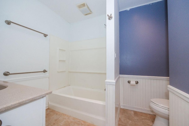 bathroom with toilet, vanity, visible vents, wainscoting, and bathing tub / shower combination