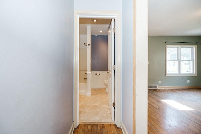 corridor with visible vents and wood finished floors