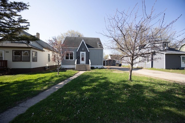 bungalow featuring driveway and a front lawn
