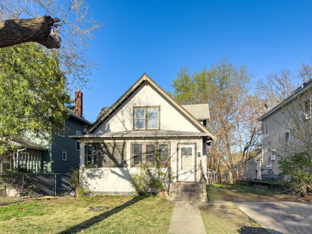view of front facade with fence, stucco siding, a chimney, and a front yard
