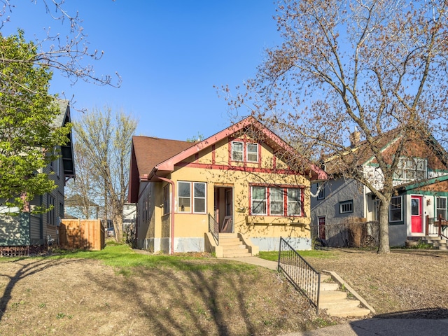 view of front of house with fence and stucco siding