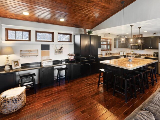 1535 148th Ln NE, Ham Lake, MN 55304 - kitchen featuring stainless steel microwave, a kitchen breakfast bar, a kitchen island, wooden ceiling, and dark wood finished floors