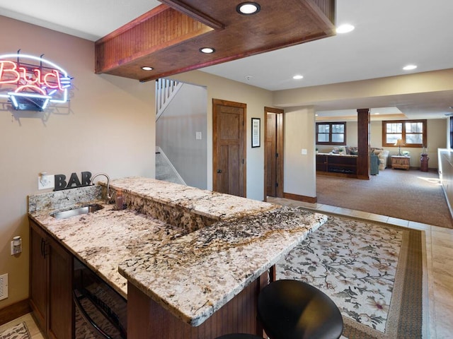 1535 148th Ln NE, Ham Lake, MN 55304 - kitchen with recessed lighting, a sink, a peninsula, light stone counters, and baseboards