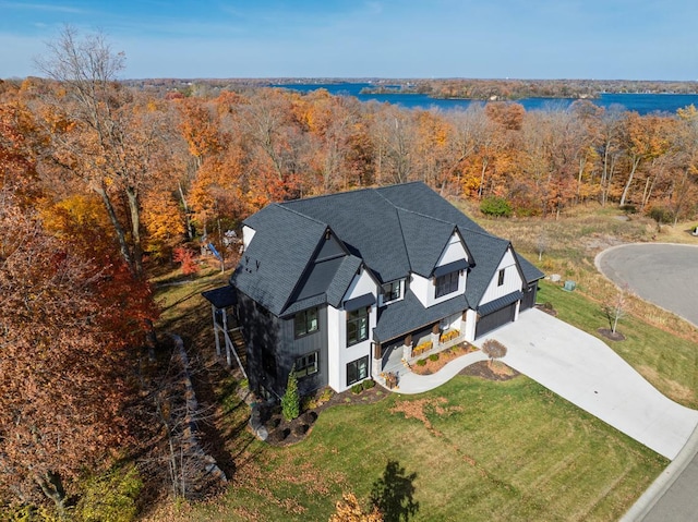 birds eye view of property with a forest view and a water view