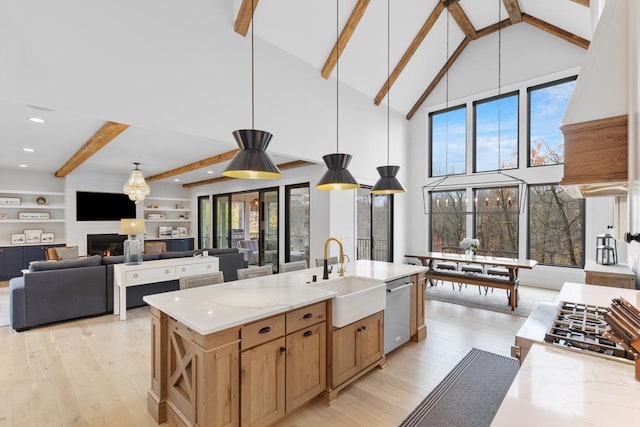 kitchen with light wood finished floors, a high ceiling, a sink, stainless steel dishwasher, and beamed ceiling