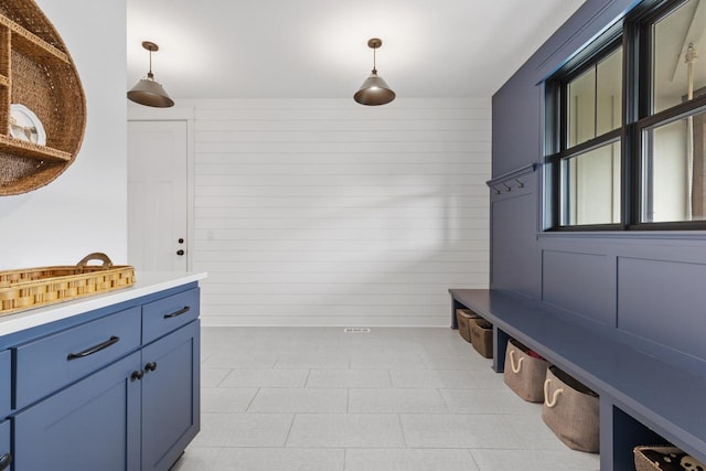 mudroom featuring wooden walls