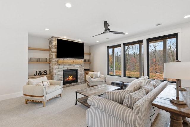 living room featuring a stone fireplace, ceiling fan, recessed lighting, and plenty of natural light
