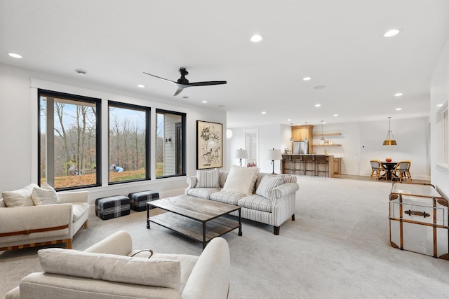 living room featuring light colored carpet, a ceiling fan, and recessed lighting