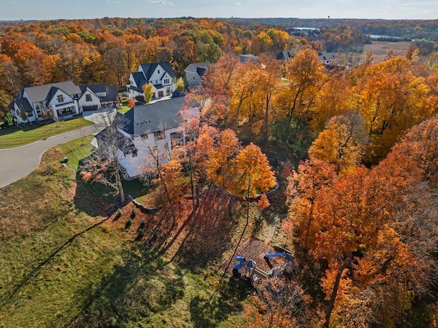 drone / aerial view featuring a wooded view and a residential view