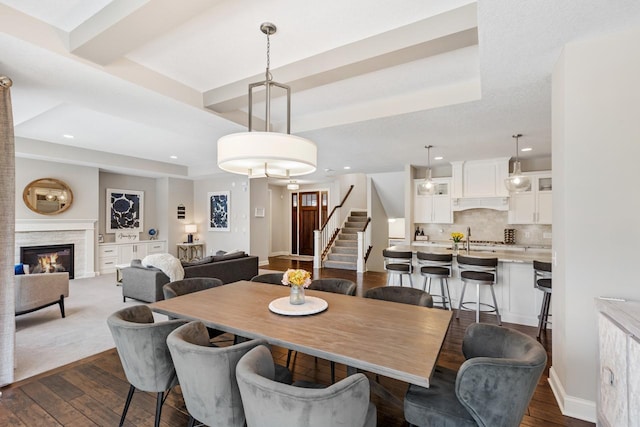 1105 Brown Rd S, Orono, MN 55391 - dining room with a stone fireplace, stairway, recessed lighting, dark wood-type flooring, and a tray ceiling