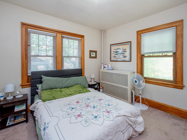 bedroom featuring carpet flooring, baseboards, and radiator heating unit
