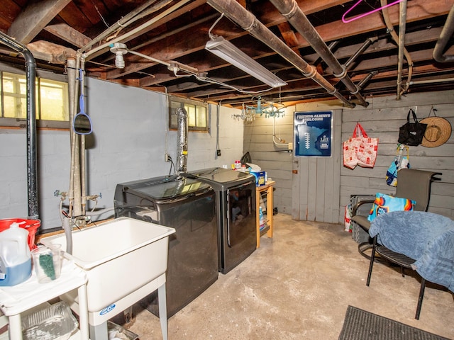 unfinished basement with washer and clothes dryer, a sink, and concrete block wall