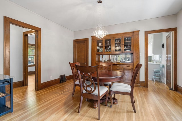 1520 Randolph Ave, Saint Paul, MN 55105 - dining area featuring a chandelier, baseboards, and light wood-style floors
