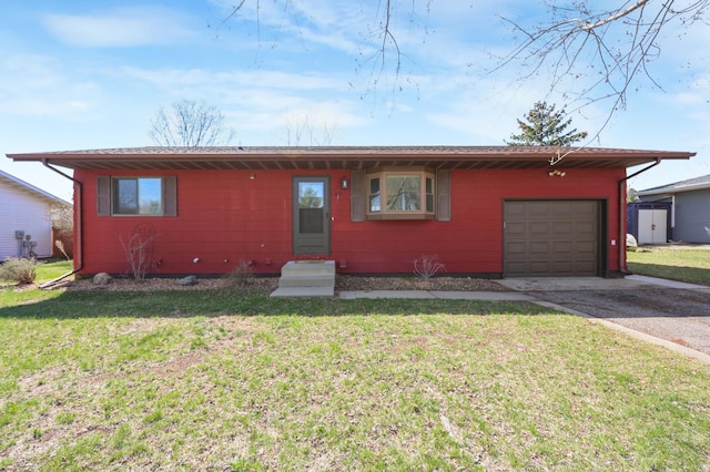 ranch-style home with a front lawn, a garage, driveway, and entry steps