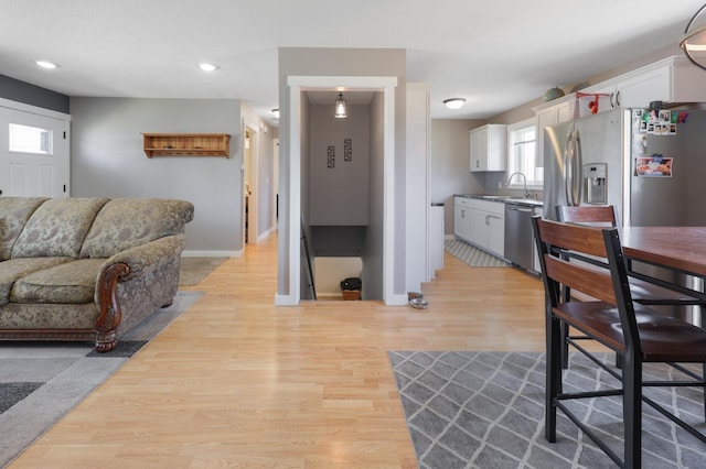 living room featuring light wood-style flooring, baseboards, and recessed lighting