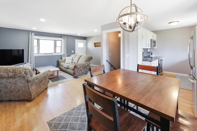 dining room with recessed lighting, light wood-style flooring, and a chandelier
