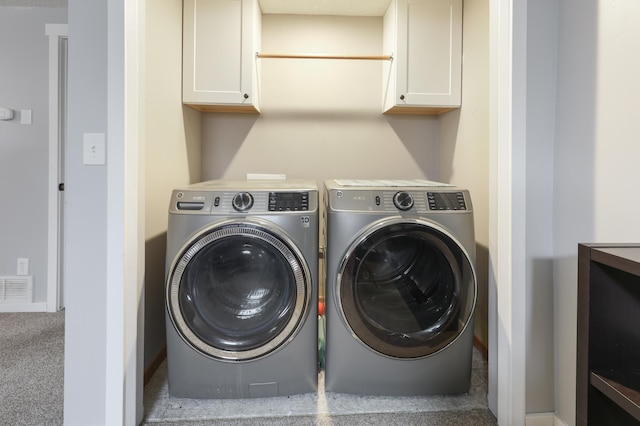 laundry room featuring independent washer and dryer, visible vents, and cabinet space