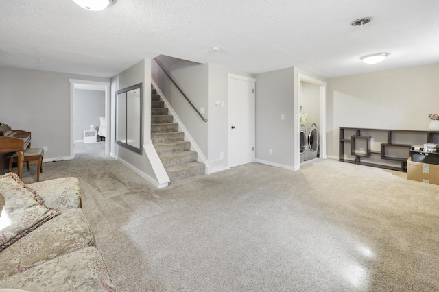 unfurnished living room with washing machine and dryer, a textured ceiling, baseboards, stairs, and carpet floors
