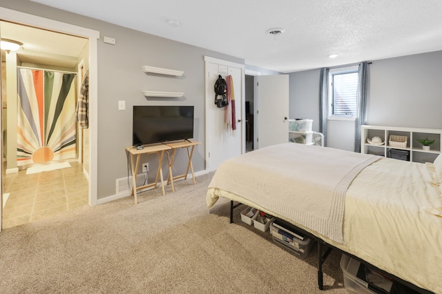 bedroom featuring a textured ceiling, carpet, baseboards, and visible vents