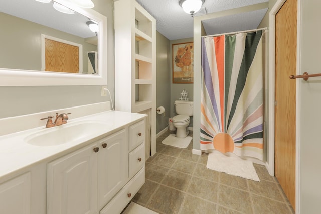 bathroom with toilet, curtained shower, vanity, and a textured ceiling