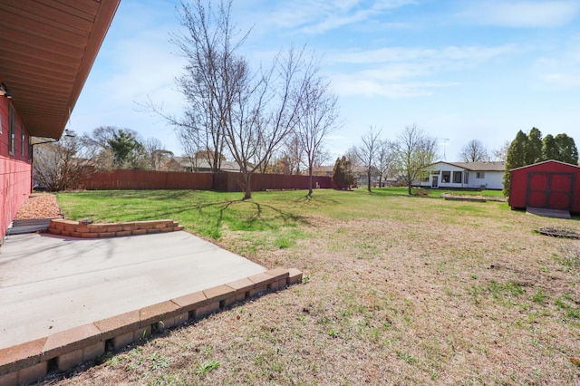 view of yard with a patio area, an outdoor structure, fence, and a storage unit