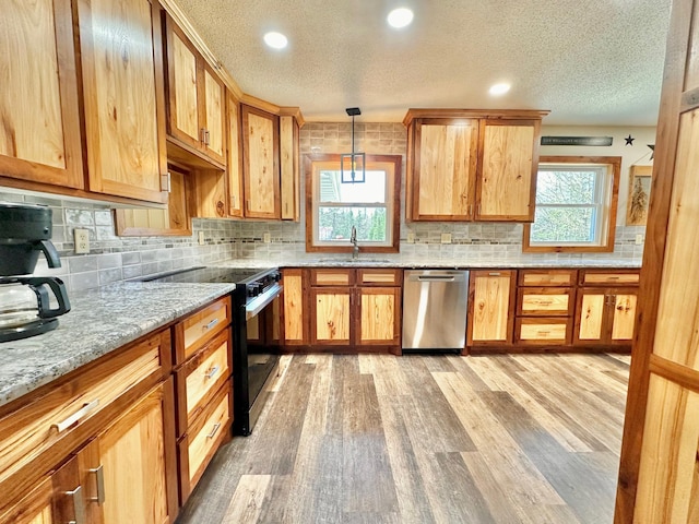 kitchen featuring stainless steel dishwasher, black electric range, a sink, light wood-type flooring, and a textured ceiling