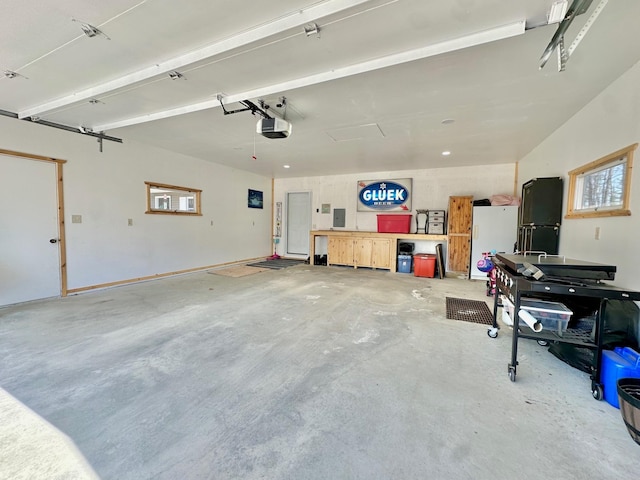 garage featuring freestanding refrigerator and a garage door opener