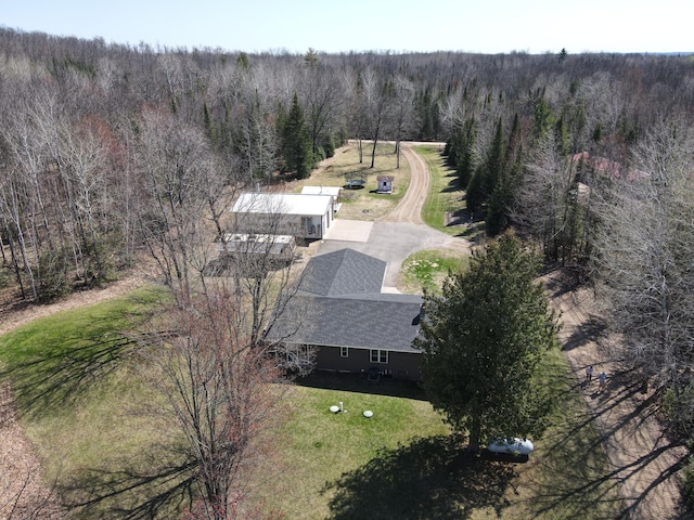 aerial view of property and surrounding area featuring a heavily wooded area