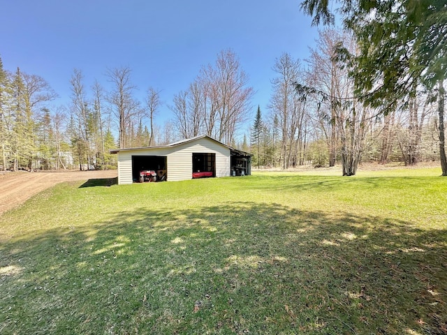 view of grassy yard with an outbuilding and a garage