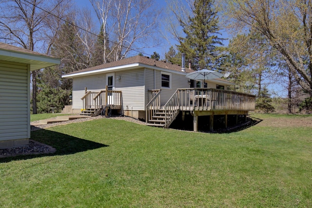 rear view of property with a wooden deck and a lawn