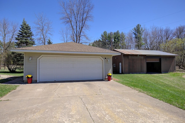 view of front of house featuring a front yard, an outdoor structure, and a detached garage