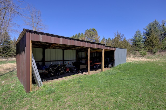 view of pole building with a detached carport and a yard