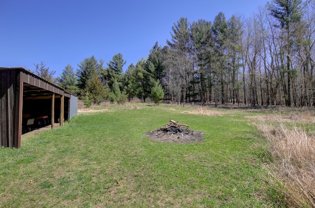 view of yard with an outdoor fire pit, an outdoor structure, and a pole building