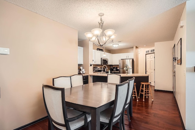 2492 Yellowstone Dr Unit 82, Hastings, MN 55033 - dining room featuring a chandelier, a textured ceiling, dark wood-style flooring, and baseboards