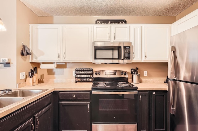 2492 Yellowstone Dr Unit 82, Hastings, MN 55033 - kitchen with stainless steel appliances, white cabinetry, light countertops, a textured ceiling, and a sink