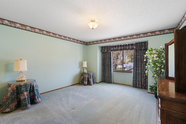 spare room with carpet floors, baseboards, and a textured ceiling