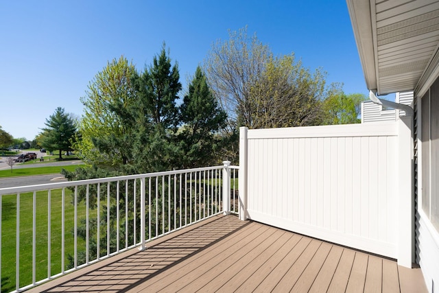 wooden deck featuring a lawn