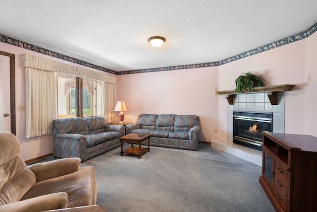 carpeted living area featuring a tiled fireplace and a textured ceiling