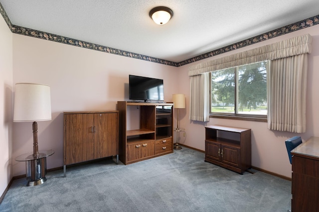 unfurnished bedroom featuring carpet, baseboards, an office area, and a textured ceiling