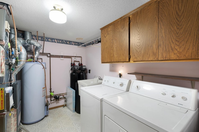 washroom featuring independent washer and dryer, cabinet space, gas water heater, a textured ceiling, and light floors