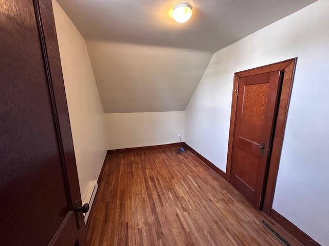 609 13th St NE, Austin, MN 55912 - bonus room featuring vaulted ceiling, wood finished floors, baseboards, and a baseboard heating unit