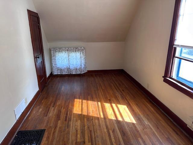 609 13th St NE, Austin, MN 55912 - additional living space featuring vaulted ceiling, wood finished floors, and baseboards