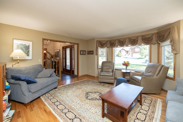 living area with wood finished floors and stairway