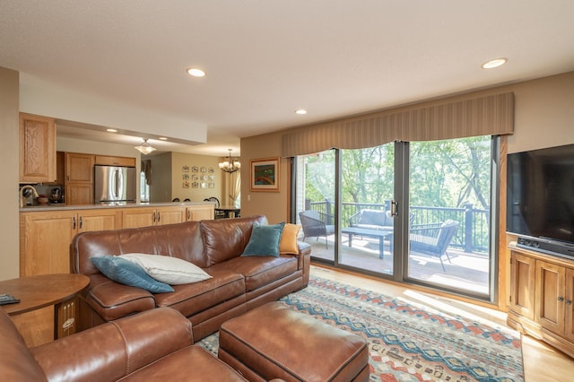 living area featuring recessed lighting, a chandelier, plenty of natural light, and light wood-style floors