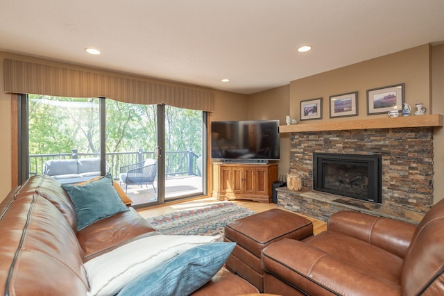 living area featuring healthy amount of natural light, recessed lighting, and a stone fireplace