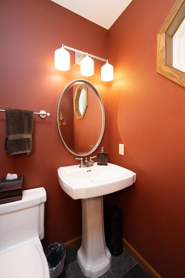 bathroom featuring tile patterned floors, baseboards, and toilet