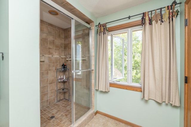full bath with a shower stall, baseboards, and tile patterned floors