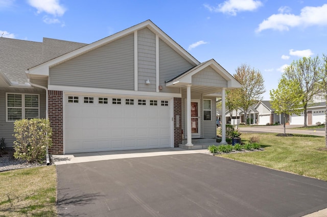 11062 16th St NE, Saint Michael, MN 55376 - view of front of property with an attached garage, asphalt driveway, brick siding, a front yard, and roof with shingles