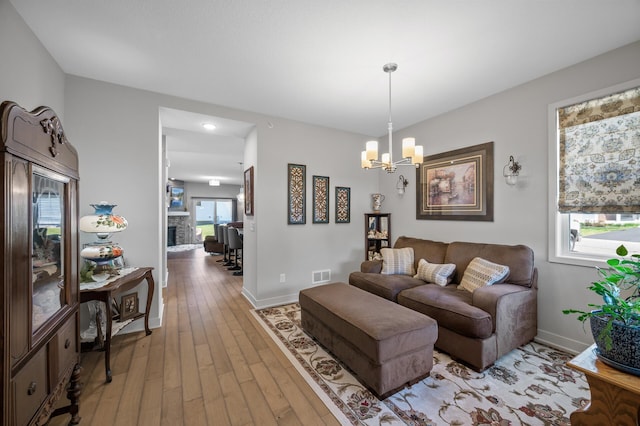 11062 16th St NE, Saint Michael, MN 55376 - living area with a chandelier, light wood-type flooring, baseboards, and a fireplace