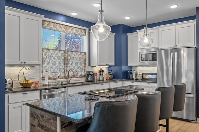 11062 16th St NE, Saint Michael, MN 55376 - kitchen featuring appliances with stainless steel finishes, a kitchen bar, a center island, a sink, and recessed lighting